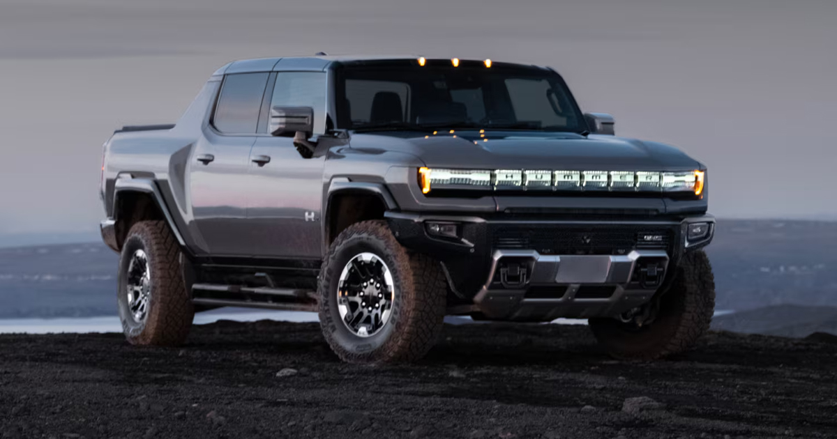 2025 GMC Hummer EV pickup truck in silver featuring distinctive LED lighting and electric vehicle design