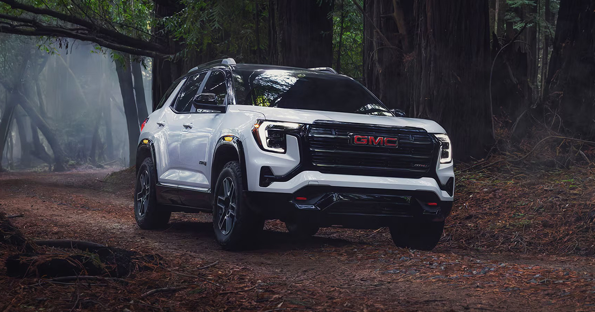 White 2026 GMC Terrain AT4 off-road trim navigating forest trail showcasing all-terrain capability