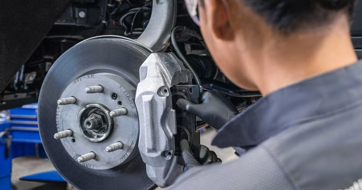Automotive service technician working on brake system components during professional vehicle maintenance
