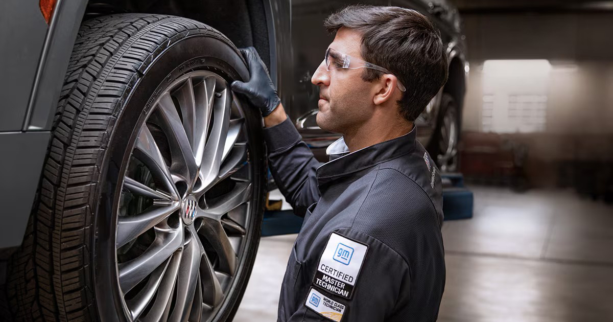 Certified Buick service technician inspecting tire for professional automotive maintenance