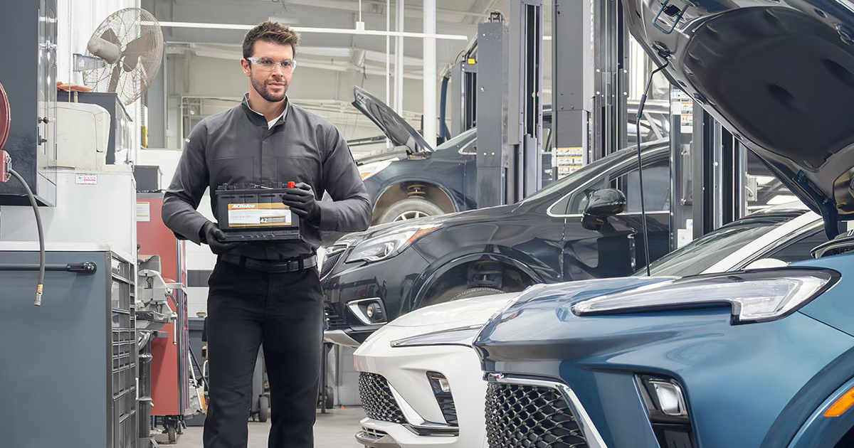 Buick certified service technician installing new vehicle battery with professional equipment