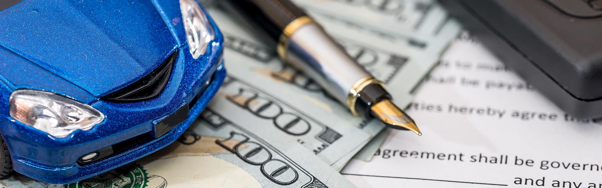 blue toy car and pen placed on money